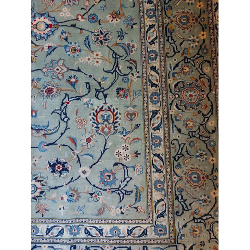 927 - A large Persian carpet, a central block overall pattern on a pale blue ground with foliage and wide ... 