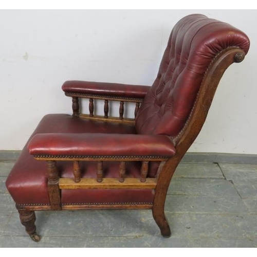 701 - A late Victorian mahogany library chair, having scrolled back and turned spindles, re-upholstered in... 