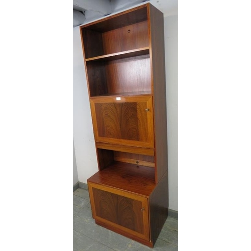 715 - A mid-century tall narrow tropical hardwood bookcase by Omman Jun, having two open shelves above cro... 