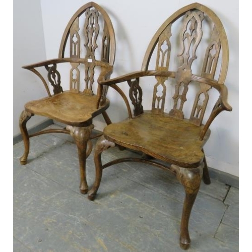 717 - A pair of well-carved vintage elm elbow chairs in a Gothic taste, the steeple backs having carved an... 