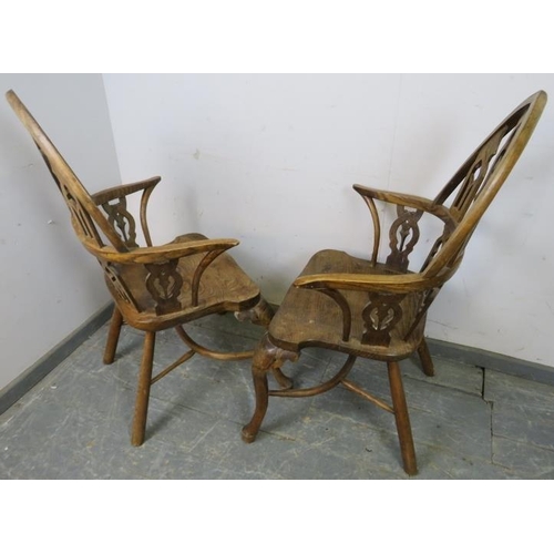 717 - A pair of well-carved vintage elm elbow chairs in a Gothic taste, the steeple backs having carved an... 