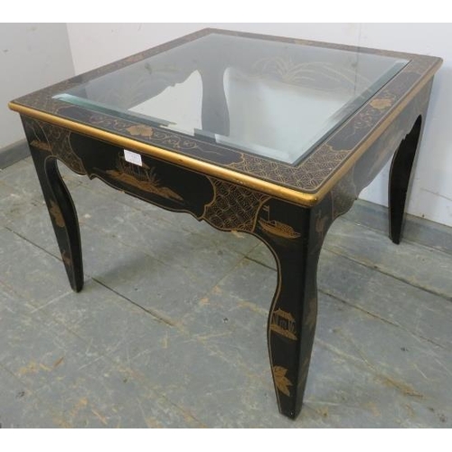 723 - A black and gold lacquer Chinoiserie side table, with inset bevelled glass top, on shaped supports. ... 