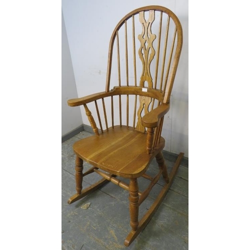 739 - A good quality hand crafted light oak Windsor rocking chair in the 19th century taste, having shaped... 