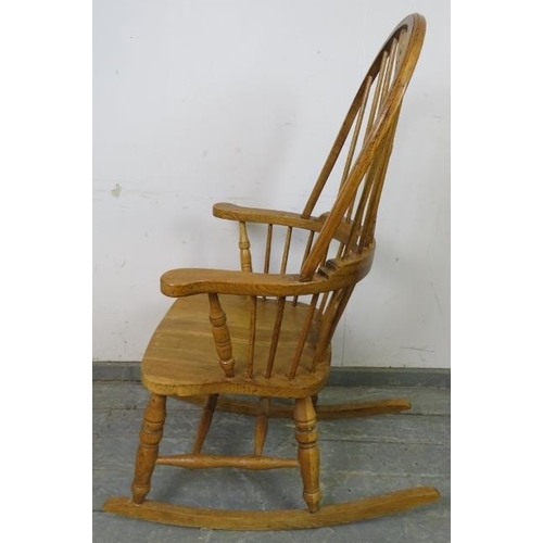 739 - A good quality hand crafted light oak Windsor rocking chair in the 19th century taste, having shaped... 