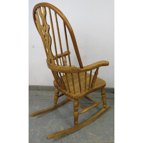 739 - A good quality hand crafted light oak Windsor rocking chair in the 19th century taste, having shaped... 