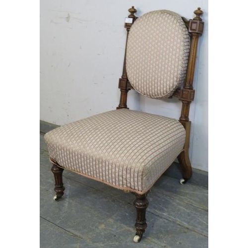 740 - A late Victorian walnut bedroom chair, having bun finials and reeded uprights, upholstered in period... 