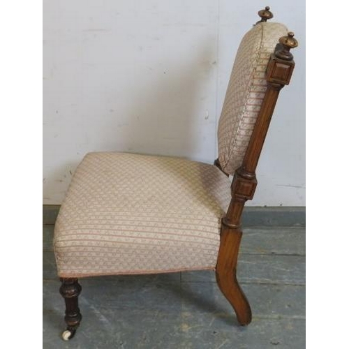 740 - A late Victorian walnut bedroom chair, having bun finials and reeded uprights, upholstered in period... 