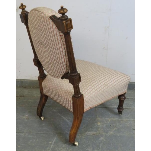 740 - A late Victorian walnut bedroom chair, having bun finials and reeded uprights, upholstered in period... 