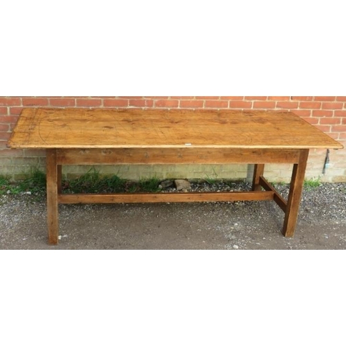 744 - An antique pine farmhouse kitchen table, of good colour and patina, on square supports with side str... 