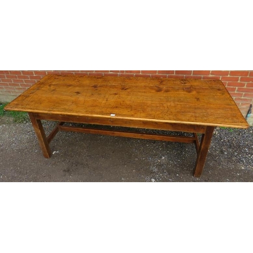 744 - An antique pine farmhouse kitchen table, of good colour and patina, on square supports with side str... 