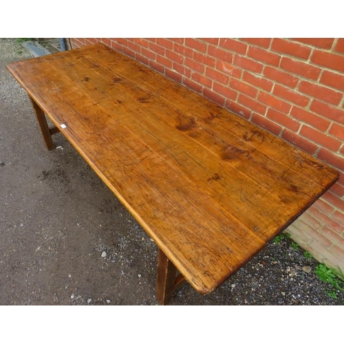 744 - An antique pine farmhouse kitchen table, of good colour and patina, on square supports with side str... 