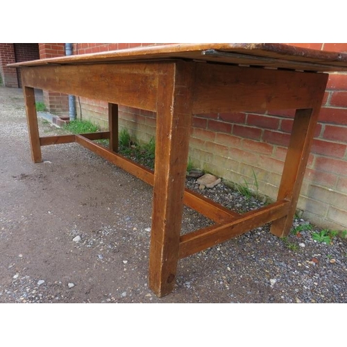 744 - An antique pine farmhouse kitchen table, of good colour and patina, on square supports with side str... 