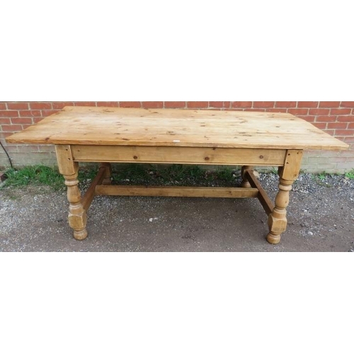 745 - An antique stripped pine farmhouse kitchen table, the planked top on baluster turned and block suppo... 