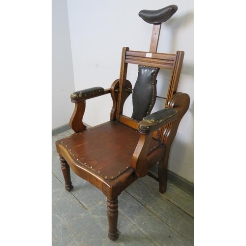 748 - A turn of the century walnut barber’s chair, having adjustable backrest and headrest, both with bras... 