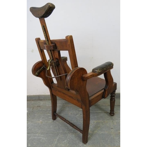 748 - A turn of the century walnut barber’s chair, having adjustable backrest and headrest, both with bras... 