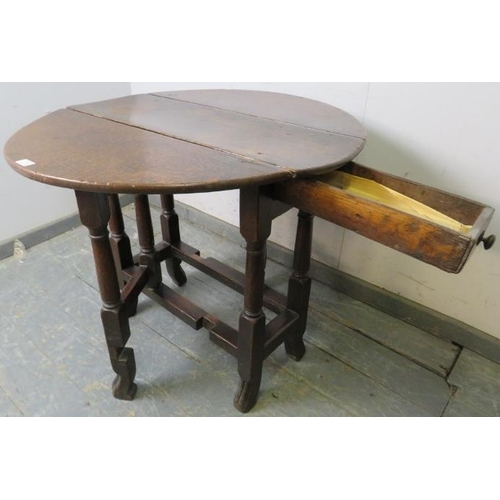 756 - An 18th century oak gate-leg table of small proportions, with single drawer, on turned and block sup... 