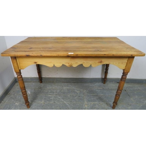 763 - An antique pine Continental kitchen table, the planked top above a shaped apron, on turned supports.... 