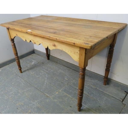 763 - An antique pine Continental kitchen table, the planked top above a shaped apron, on turned supports.... 