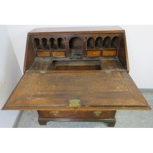 764 - An 18th century medium oak bureau, crossbanded and with olive wood inlay, the fall front enclosing a... 