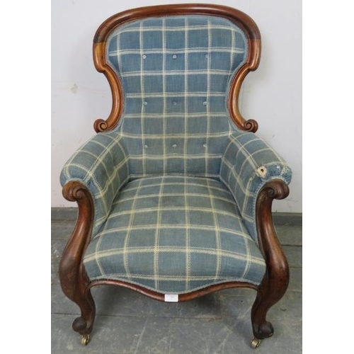 785 - A Victorian mahogany spoonback armchair, reupholstered in blue chequered woollen material, having sc... 