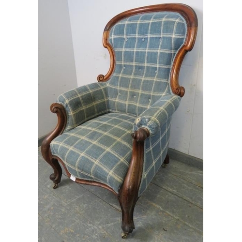 785 - A Victorian mahogany spoonback armchair, reupholstered in blue chequered woollen material, having sc... 