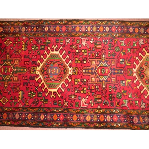 918 - North West Persian Heriz runner, central repeat pattern on a red ground, 395cm x .78cm.
Condition re... 