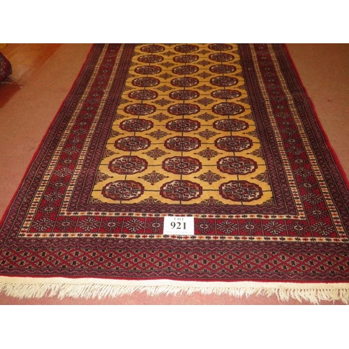 921 - A Persian rug, central repeat pattern on cream ground on red, with wide borders, 181cm x 127cm.
Cond... 