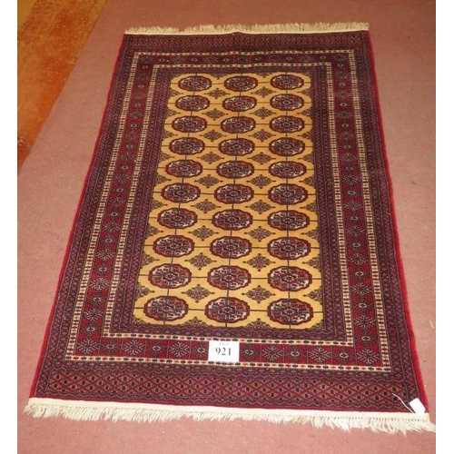 921 - A Persian rug, central repeat pattern on cream ground on red, with wide borders, 181cm x 127cm.
Cond... 