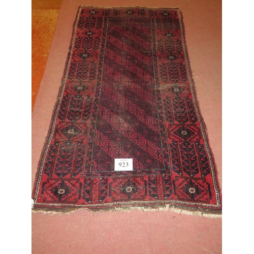 923 - An early 20th Century Persian rug on burgundy ground (even wear). 100cm x 190cm.