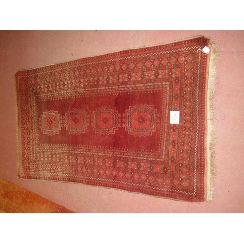 926 - An antique Persian rug, central panel with 3 motifs and deep borders on red ground, 210cm x 128cm.
C... 