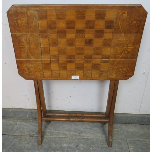 767A - An Edwardian walnut folding table with chessboard top, on curved supports with turned stretchers. 
H... 