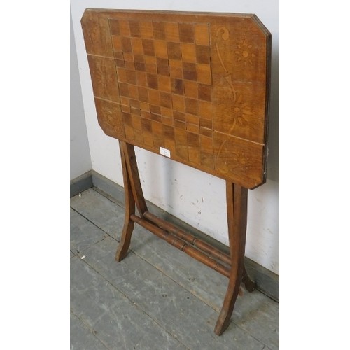 767A - An Edwardian walnut folding table with chessboard top, on curved supports with turned stretchers. 
H... 