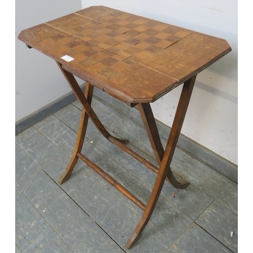 767A - An Edwardian walnut folding table with chessboard top, on curved supports with turned stretchers. 
H... 