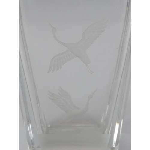 13 - An Orrefors Swedish clear crystal glass vase, 20th century. Engraved with cranes in flight above a r... 