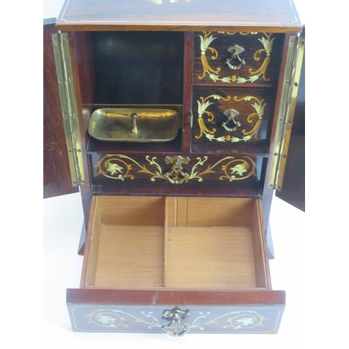 138 - Tobacconalia: An Edwardian rosewood and marquetry inlaid smokers cabinet. Decorated with cherubs, my... 