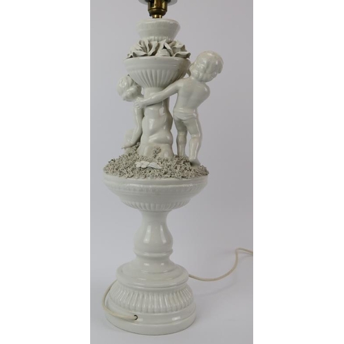 162 - An Italian white porcelain table lamp, 20th century. Modelled with putti. 47 cm height. Condition re... 