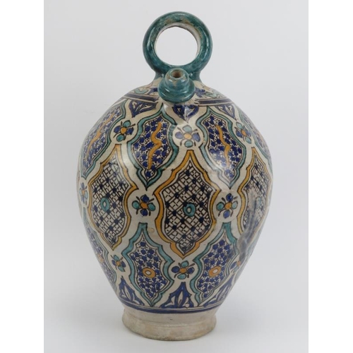 23 - A large Moroccan tin glazed pottery water decanter jug. Modelled with a loop handle and two spouts (... 