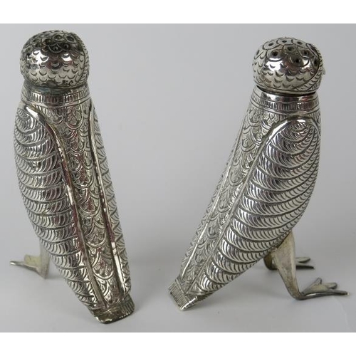 312 - A pair of Indian white metal pepperettes in the form of birds with red glass eyes. Height 9cm. Gross... 