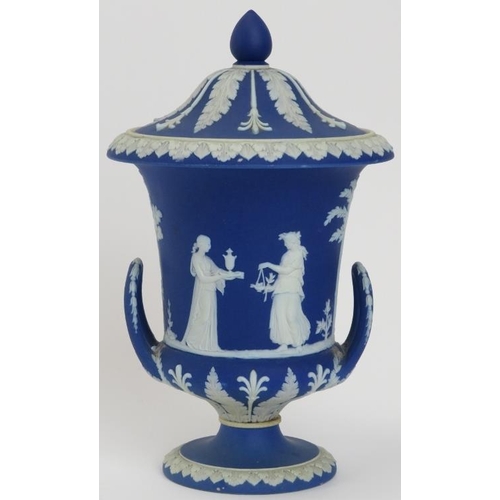 32 - A Wedgwood blue jasperware twin handled campana urn with cover, 19th century. Applied decoration in ... 