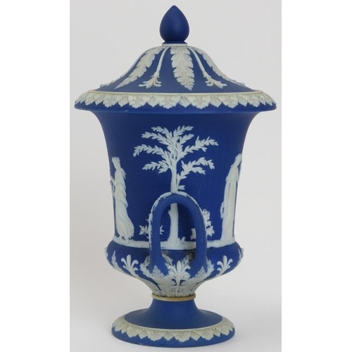 32 - A Wedgwood blue jasperware twin handled campana urn with cover, 19th century. Applied decoration in ... 