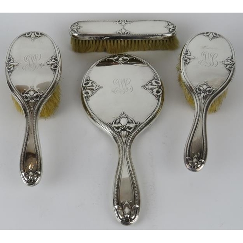 321 - A four piece Art Nouveau silver backed vanity set comprising two hair brushes, clothes brush and a b... 