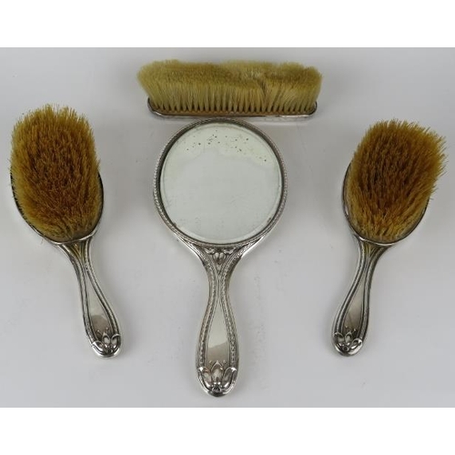 321 - A four piece Art Nouveau silver backed vanity set comprising two hair brushes, clothes brush and a b... 