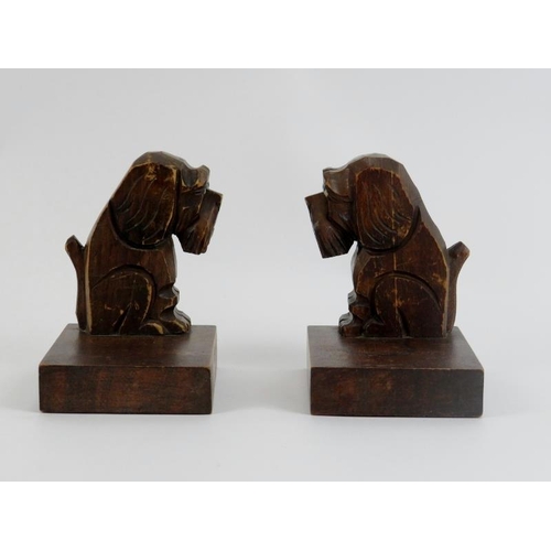 34 - A pair of Black Forest dog bookends, early 20th century. The carved wood seated dogs modelled with g... 