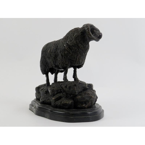 35 - A bronzed metal figure of a ram on a rocky outcrop, 20th century. Supported on a marble base. 21.3 c... 