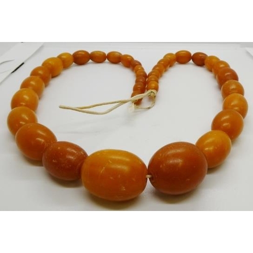 368 - A Butterscotch amber bead necklace, having 35 graduated oval beads, 520mm long, smallest bead 9.85mm... 