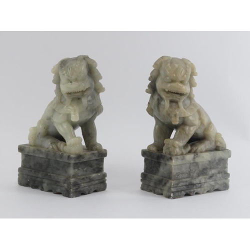 82 - A pair of Chinese carved soapstone Buddhistic temple lions on plinths, 20th century. (2 items) 25 cm... 