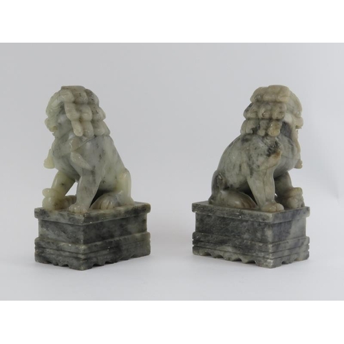 82 - A pair of Chinese carved soapstone Buddhistic temple lions on plinths, 20th century. (2 items) 25 cm... 