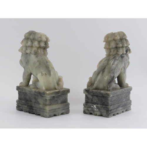 82 - A pair of Chinese carved soapstone Buddhistic temple lions on plinths, 20th century. (2 items) 25 cm... 