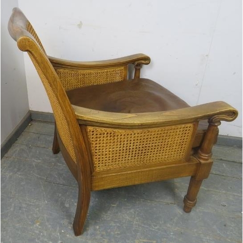 702 - An antique style fruitwood armchair, having double skin bergère back and sides, with loose cushions ... 