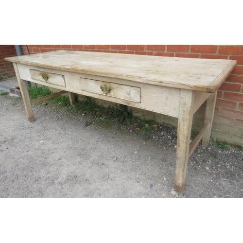 705 - An antique scrubbed elm farmhouse kitchen table, having two short frieze drawers with brass handles,... 